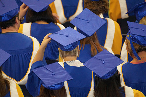 graduates standing their graduation hats