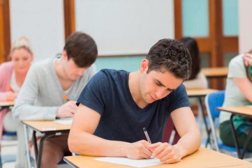 students sitting at a desk and writing