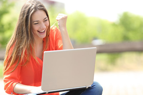 excited student on a laptop